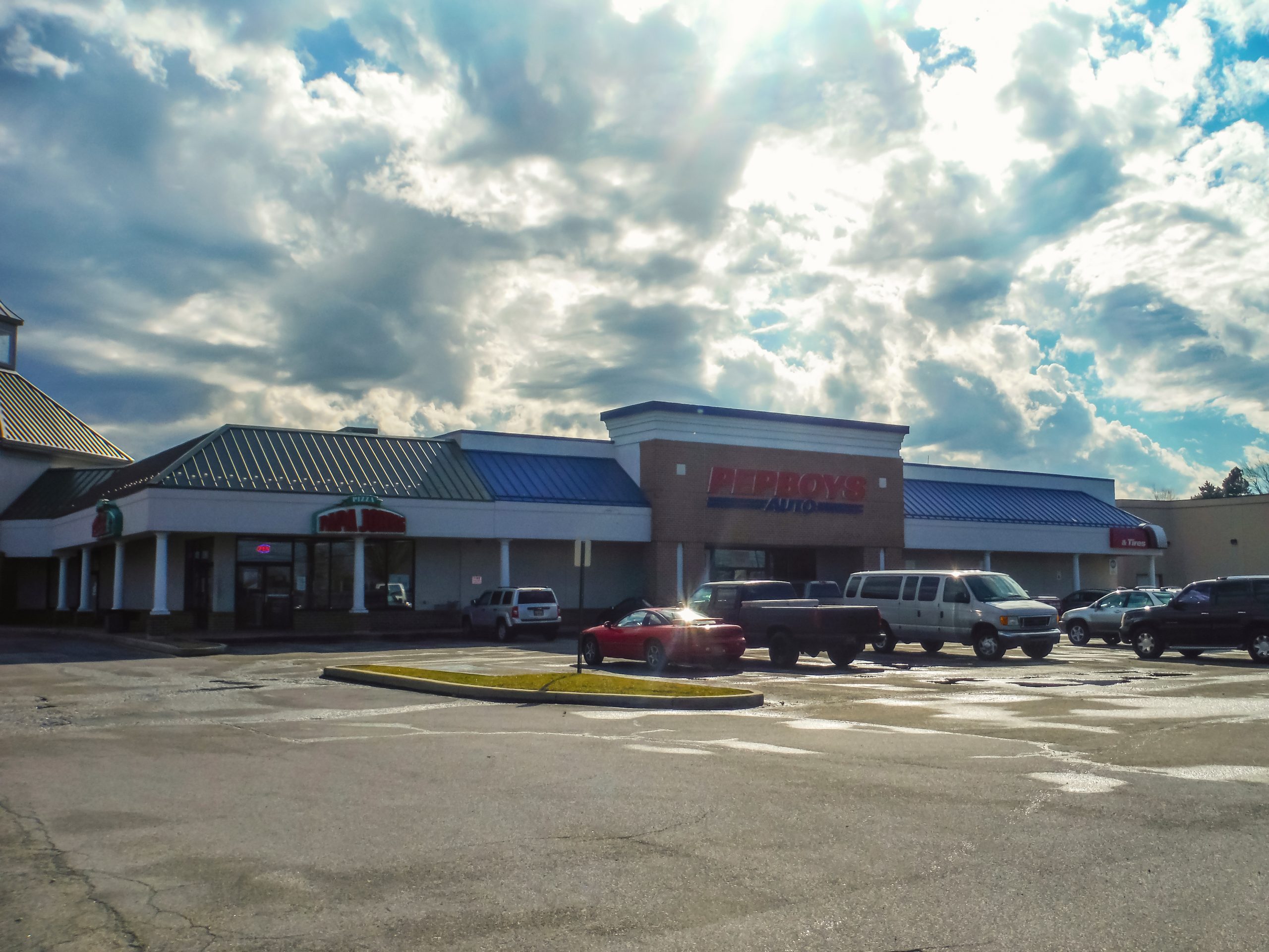 Strip mall storefront with Pep Boys Auto and Papa John's signage, plus a parking lot in Glendale Plaza Shopping Center.