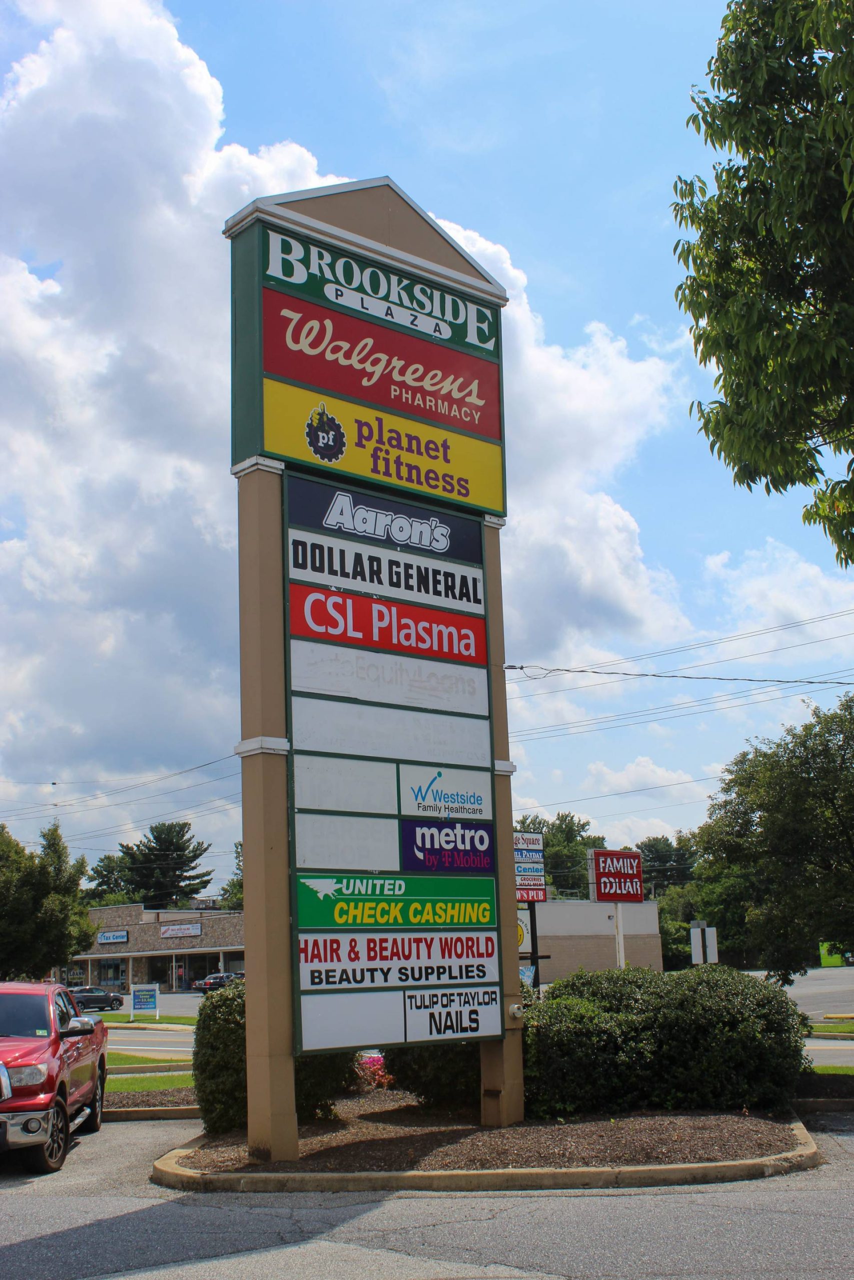 Brookside Plaza pylon sign listing tenants including Walgreens, Planet Fitness, Aaron's, Dollar General, and CSL Plasma along a Wilmington, DE roadway.