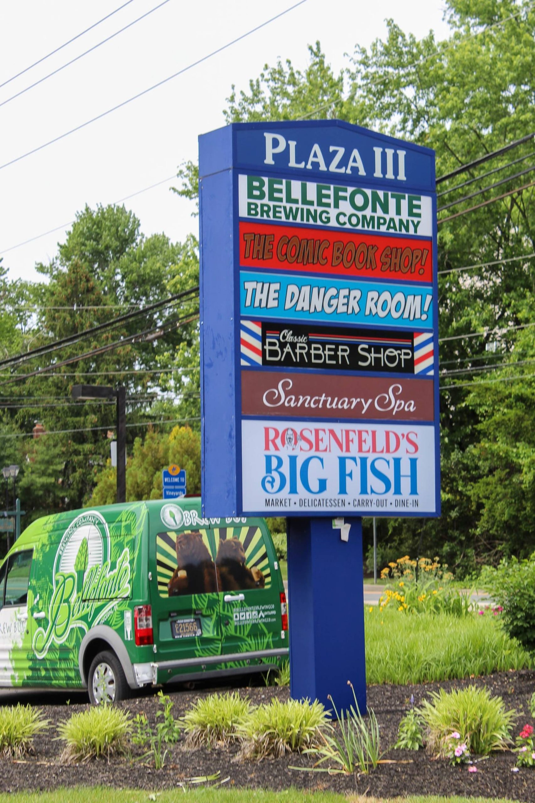 Plaza III tenant directory sign lists Bellefonte Brewing, comic book shop, barber shop, spa, and Rosenfeld's Big Fish market with a brewery van parked nearby.