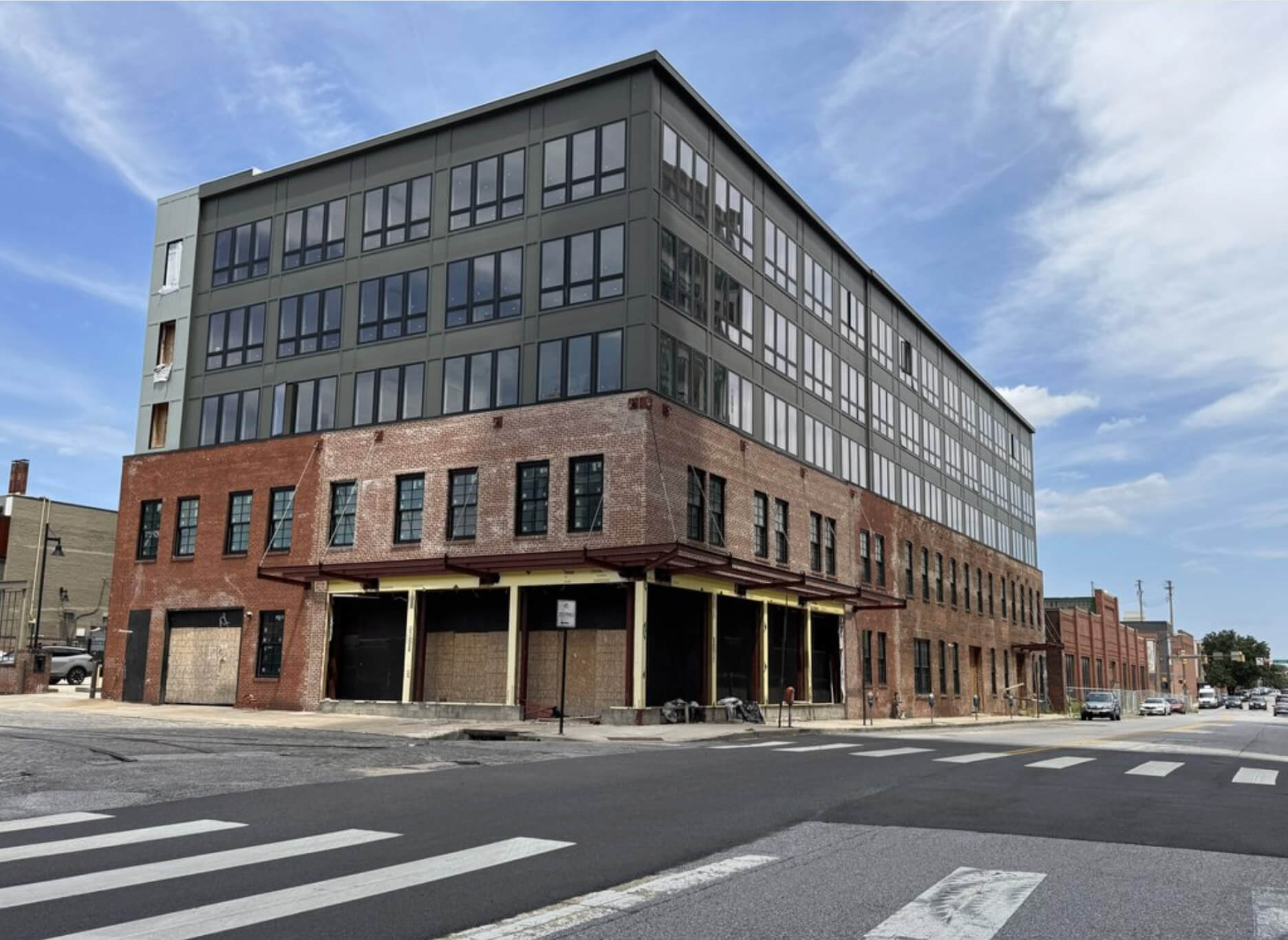 Mixed-use building at 1400 Aliceanna Street combines original brick lower floors with modern glass and metal upper stories under construction.